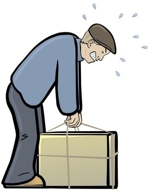 Ein Mann zieht mit Anstrengung an einem Seil, das an einem großen Kasten befestigt ist.