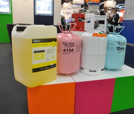 Drei Behälter mit verschiedenen Farben und Beschriftungen stehen nebeneinander auf einem bunten Podest.