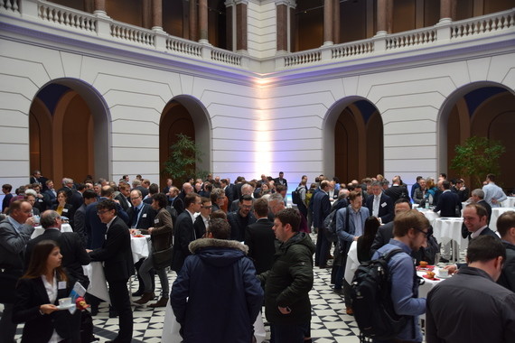 Eine Menschenmenge in einem eleganten Saal bei einer Veranstaltung oder Networking-Veranstaltung.