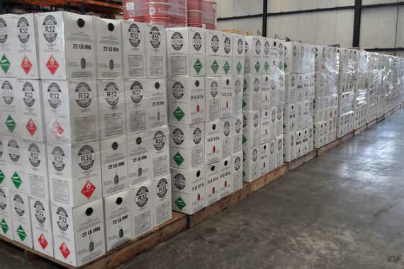 Eine große Anzahl von weißen Kartons ist in Reihen aufgestapelt in einem Lagerhaus.