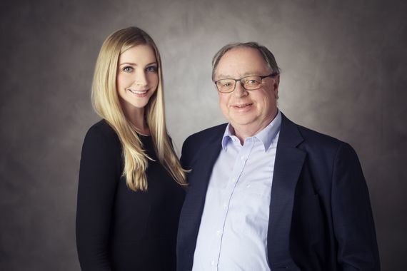 Zwei Personen, eine Frau und ein Mann, stehen nebeneinander vor einem neutralen Hintergrund.