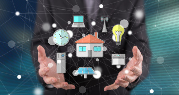 Eine Person hält verschiedene Symbole wie Uhr, Laptop, Haus, Glühbirne, Solarpanel, Auto und Fernseher in den Händen vor einem digitalen Netzwerk-Hintergrund.