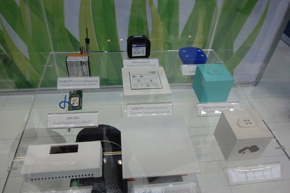 Eine Ausstellung von verschiedenen elektronischen Komponenten und Geräten auf einem Tisch vor einem grünen Hintergrund.