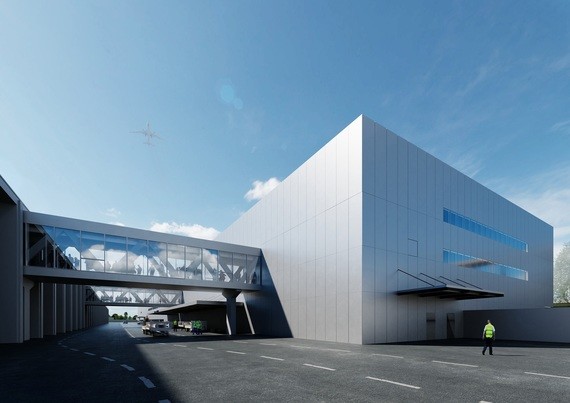 Moderne, schlichte Architektur eines großen Gebäudes mit klaren Linien, großen Fensterflächen und einer überdachten Einfahrt.