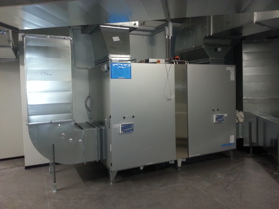 Ein Bild von einer industriellen Küche mit Metallgeräten, Schränken und einer Kühlanlage.