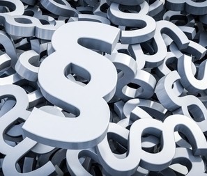 Ein Haufen von stilisierten Paragraphensymbolen (§) in Grau und Weiß.