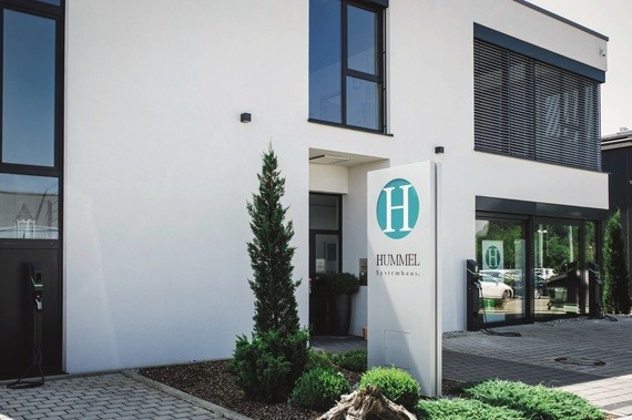 Ein modernes Gebäude mit einer Schilderstütze, auf der das Logo und der Name 