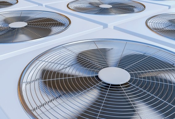 Ein Bild von mehreren großen, runden Klimaanlagen mit Metallgittern und rotierenden Ventilatoren.