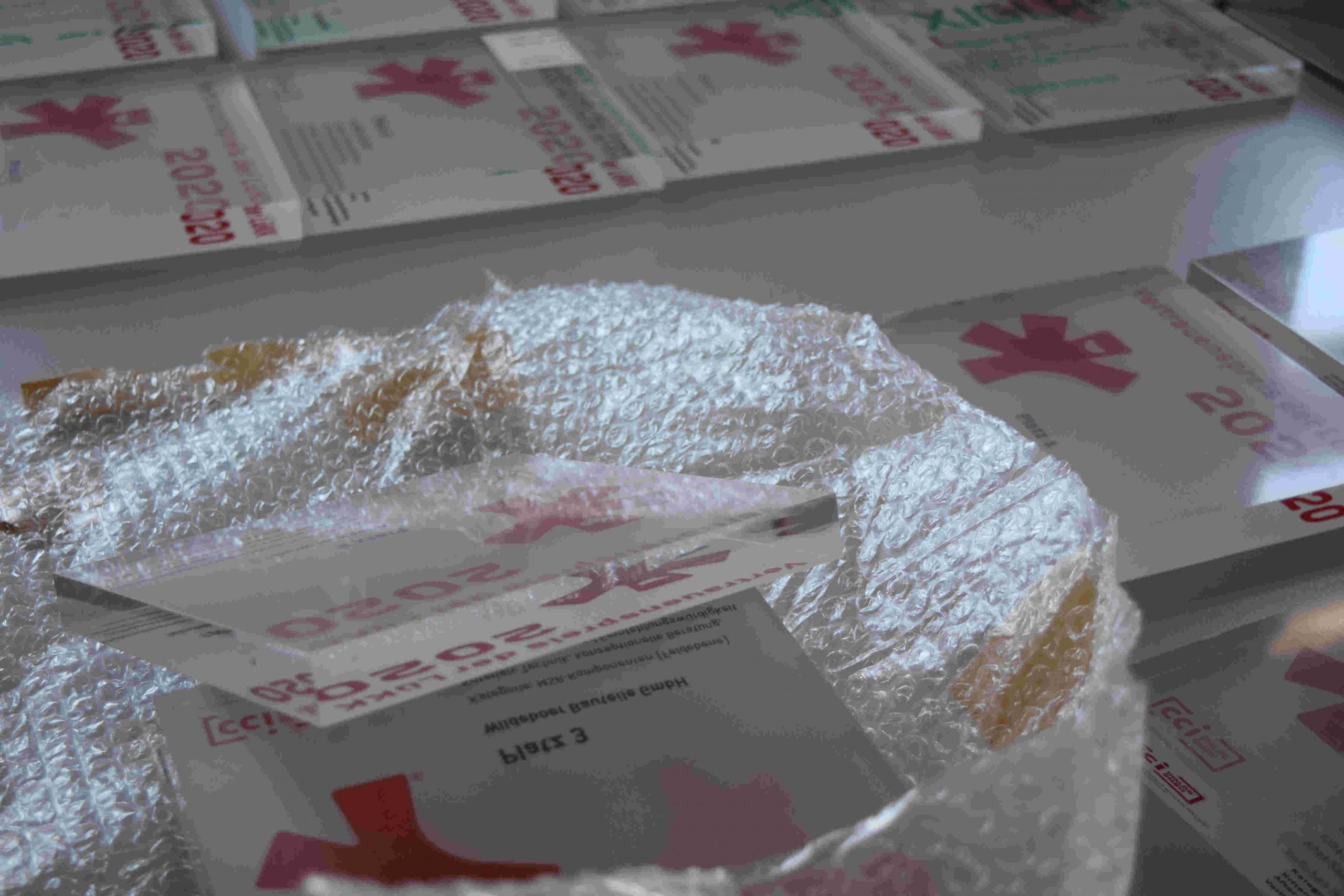 Ein Stapel medizinischer Verpackungen mit roten Kreuzsymbolen und weißem Pulver in der Vordergrundverpackung.