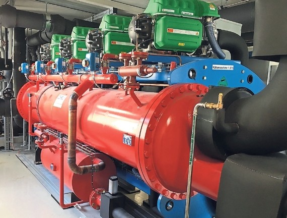 Ein Bild von industriellen Maschinen mit roten und blauen Komponenten in einer Werkshalle.