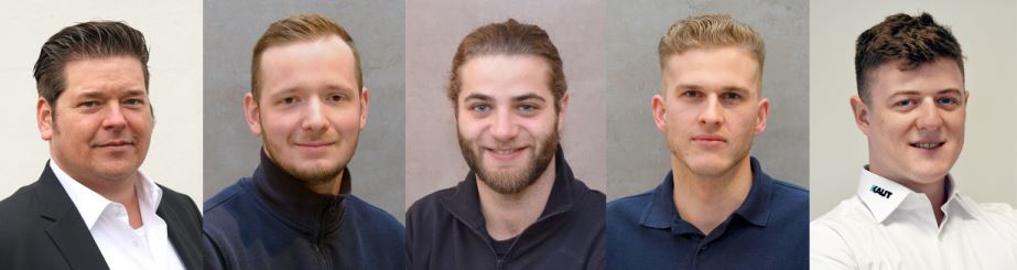 Vier Männer mit kurzen Haaren und lächelnden Gesichtern stehen nebeneinander.