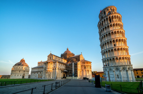 Eine beleuchtete Ansicht der schiefen Turm von Pisa und der Kathedrale von Pisa bei Sonnenuntergang.