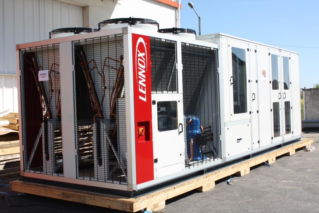 Ein großes, kabelgebundenes Lenovo-Gerät in einem Metallgehäuse steht auf einem Holzpalette.