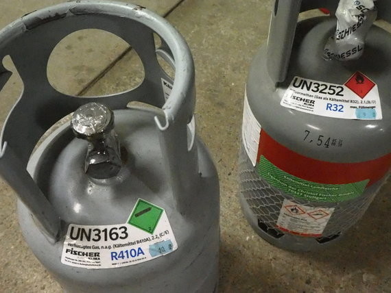 Zwei Gasflaschen mit Beschriftungen für R310A und R32 sowie UN-Nummern 3163 und 3252.