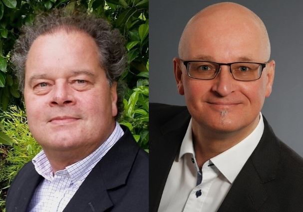 Das Bild zeigt zwei Männer nebeneinander: Der linke trägt ein Hemd und Jacke, der rechte ein Hemd und Krawatte.