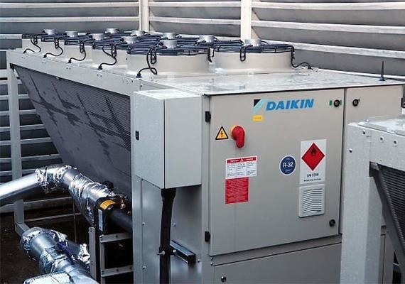 Ein Daikin-Klimaanlagen-Gerät mit Rohrleitungen und Warnhinweisen auf einer industriellen Plattform.