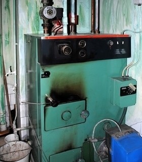 Ein industrieller Boiler mit verschiedenen Rohrleitungen, Messgeräten und einem digitalen Display.