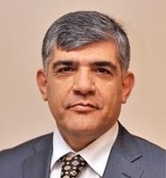 Ein Mann in einem Anzug und Krawatte mit ernstem Gesichtsausdruck.