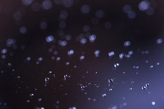 Ein abstraktes Bild mit einem dunklen Hintergrund und leuchtenden, punktförmigen Lichtern, die wie Sterne oder Nebel erscheinen.