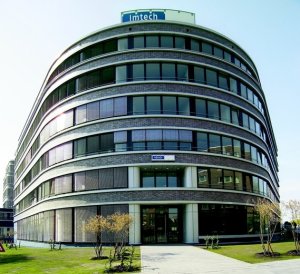 Ein modernes, großes Bürogebäude mit einer gerundeten Fassade und dem Logo 