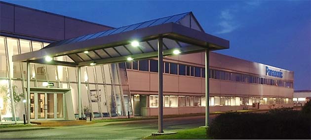 Ein modernes Bürogebäude mit einem markanten Vordach und dem Firmenschild 