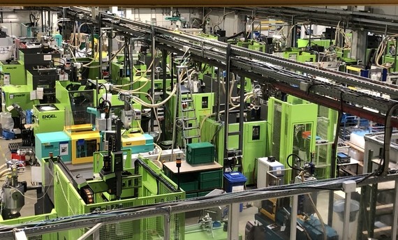 Eine moderne Produktionshalle mit mehreren CNC-Fräsmaschinen und einer komplexen Förderanlage.