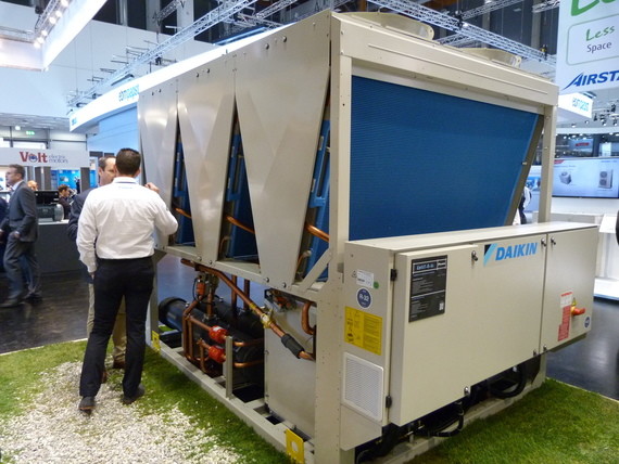 Zwei Personen stehen neben einem großen industriellen Klimagerät mit blauen Türen und der Aufschrift 