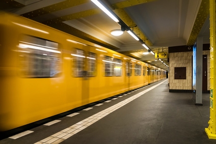 Ein gelbes U-Bahn-Zugfahrzeug steht an einem Bahnsteig in einer unterirdischen Station.