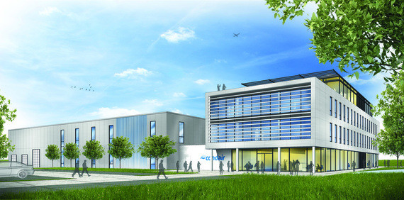 Ein modernes Bürogebäude mit großen Fenstern, grüner Rasen und Bäumen im Vordergrund.