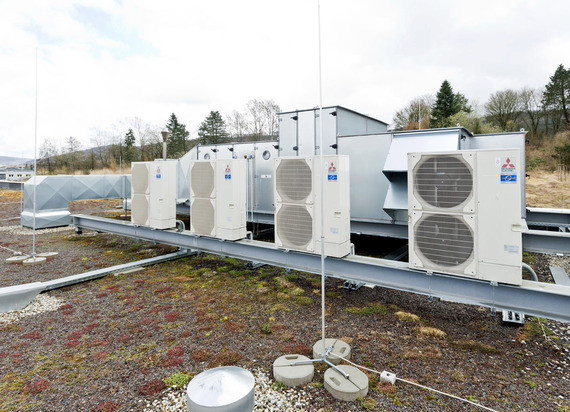 Ein Bild von mehreren großen Klimaanlagen oder Kühlaggregaten, die auf einem Dach installiert sind.