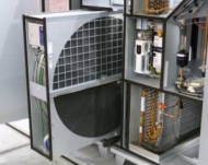 Ein technisches Gerät mit einem großen runden Filterelement und einem offenen Kasten, der elektrische Komponenten enthält.