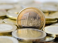 Ein Haufen von Euro-Münzen, darunter eine 1-Euro-Münze im Vordergrund.