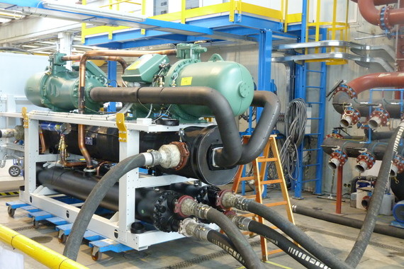 Ein industrieller Anlagenbereich mit großen Maschinen, Rohrleitungen und Montageplattformen.