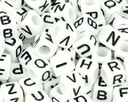 Ein Haufen weißer Perlen mit schwarzen Buchstaben darauf.