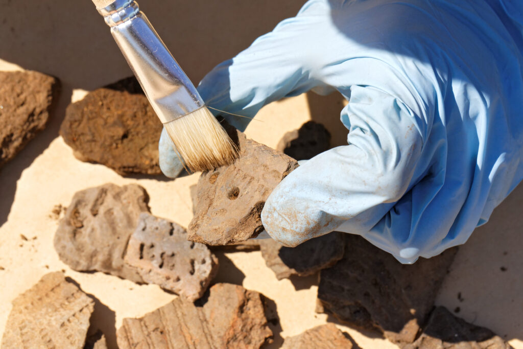 Die Studenten von Archäologieprofessoir Hebeschatz sollen ein möglichst großes rechteckiges Grabungsfeld abstecken (Abb. © Krugloff/stock.adobe.com)