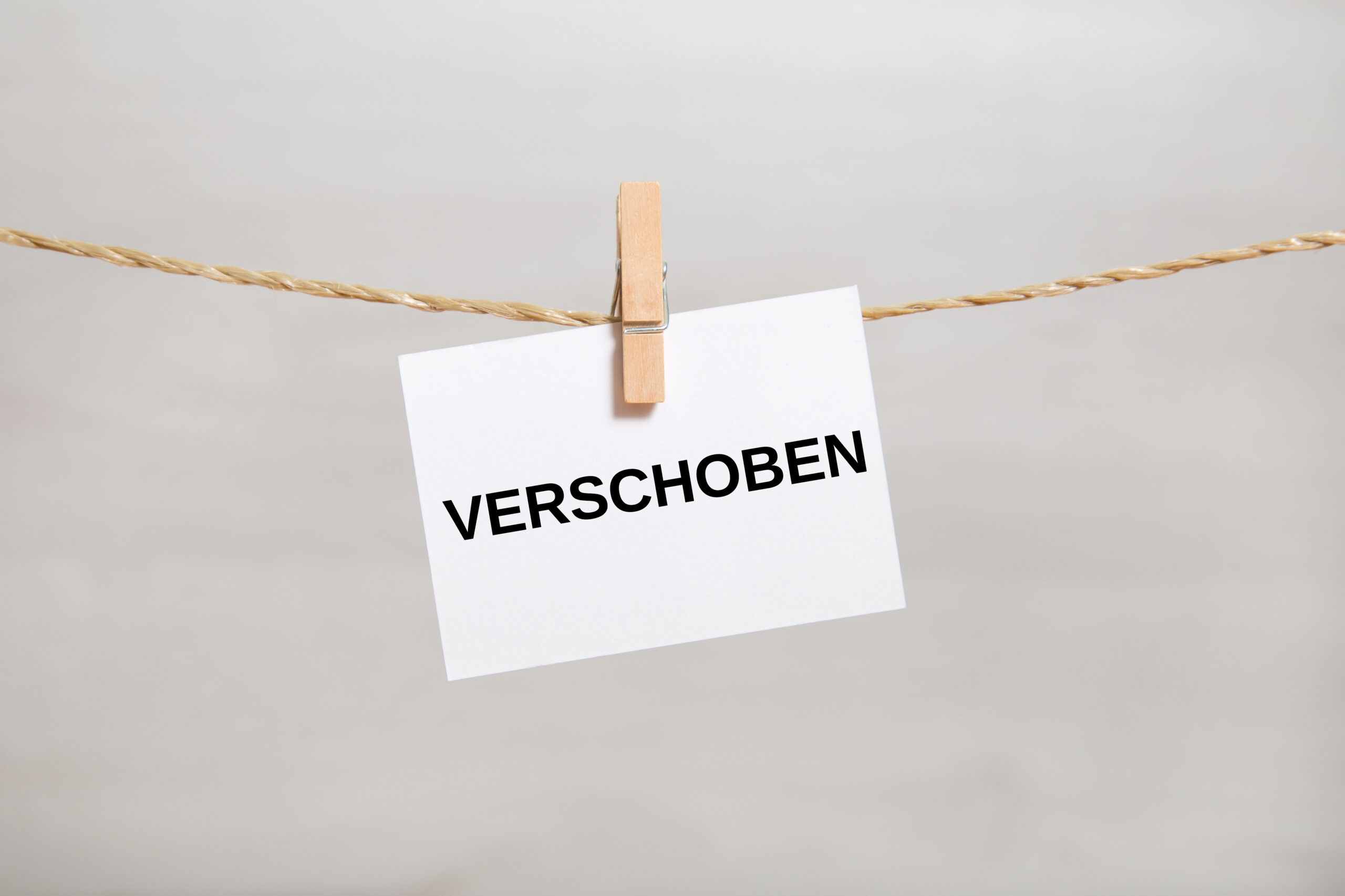 Ein Mann mit Brille und blauem Hemd sitzt vor einem Bücherregal.